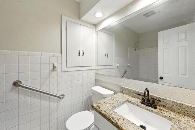 5103 Stone Gate Dr, Austin, TX 78721 - bathroom featuring tile walls, vanity, and tiled shower