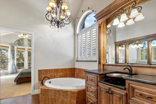 12013 Tarraza Ct, Austin, TX 78732 - ensuite bathroom with a chandelier, a garden tub, vanity, a towering ceiling, and wood finished floors