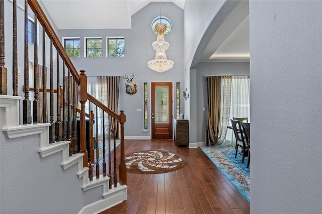 12013 Tarraza Ct, Austin, TX 78732 - foyer entrance with hardwood / wood-style floors, arched walkways, baseboards, stairway, and high vaulted ceiling