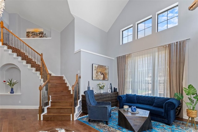 12013 Tarraza Ct, Austin, TX 78732 - living room with high vaulted ceiling, stairs, wood finished floors, and baseboards
