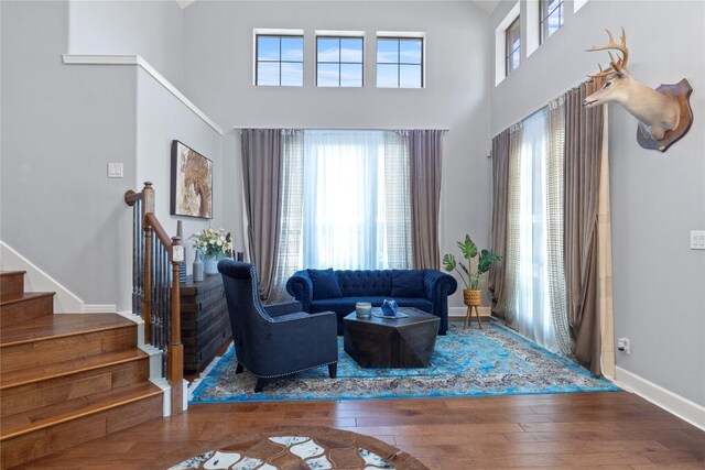 12013 Tarraza Ct, Austin, TX 78732 - living area with stairway, healthy amount of natural light, wood-type flooring, a high ceiling, and baseboards
