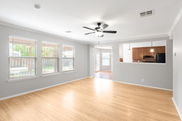 601 Abundance Ln, Kyle, TX 78640 - unfurnished living room featuring ornamental molding, a ceiling fan, light wood-style floors, and baseboards