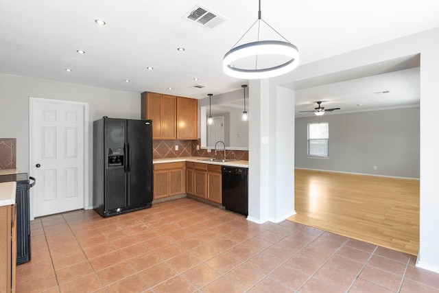 601 Abundance Ln, Kyle, TX 78640 - kitchen with black appliances, a sink, light tile patterned floors, decorative backsplash, and decorative light fixtures
