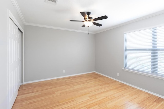 601 Abundance Ln, Kyle, TX 78640 - unfurnished bedroom with light wood-style flooring, a closet, baseboards, ornamental molding, and a ceiling fan