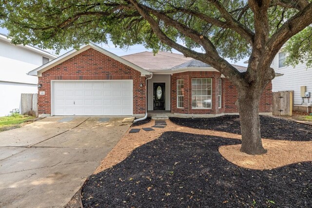view of front of home featuring brick siding, a garage, driveway, and a shingled roof