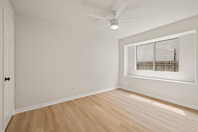 empty room featuring light wood-style flooring, baseboards, and ceiling fan