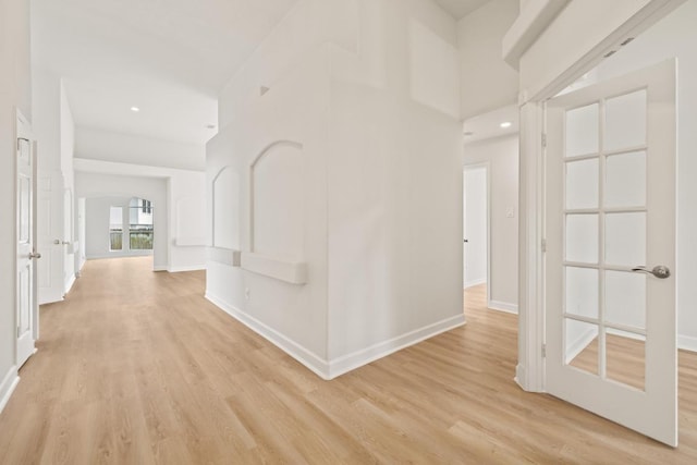 hall with light wood-style flooring, baseboards, and recessed lighting