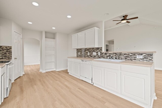 kitchen with white appliances, a sink, ceiling fan, decorative backsplash, and white cabinets