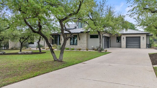 13213 Meridian Park Blvd, Austin, TX 78739 - view of front facade with a standing seam roof, a garage, driveway, stone siding, and a front yard