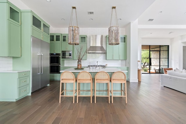 13213 Meridian Park Blvd, Austin, TX 78739 - kitchen with wall chimney exhaust hood, green cabinets, built in appliances, a chandelier, and tasteful backsplash