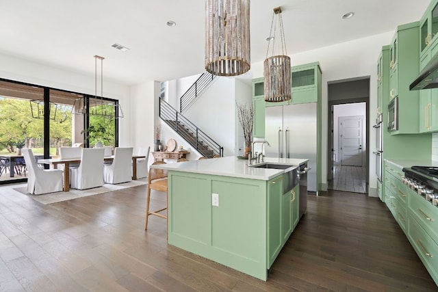 13213 Meridian Park Blvd, Austin, TX 78739 - kitchen with green cabinets, dark wood-style flooring, a kitchen island with sink, light countertops, and recessed lighting