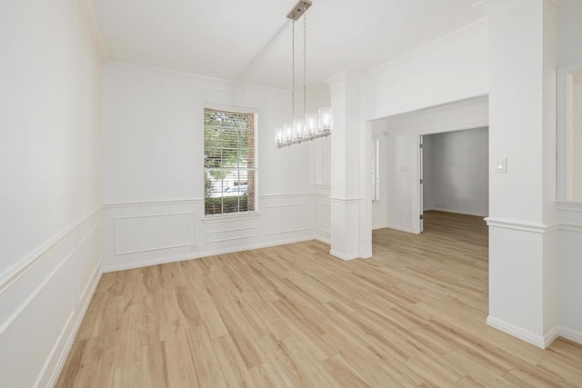 unfurnished dining area with ornamental molding, light wood-style floors, and a chandelier