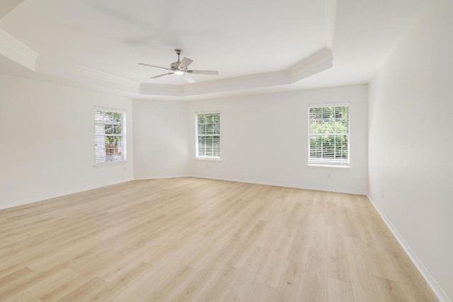 12207 Carlsbad Dr, Austin, TX 78738 - empty room featuring a tray ceiling, light wood finished floors, plenty of natural light, ceiling fan, and ornamental molding