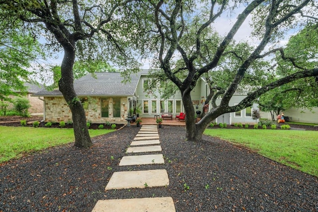 10305 Pickfair Dr, Austin, TX 78750 - view of front of house with stone siding, a front yard, and roof with shingles