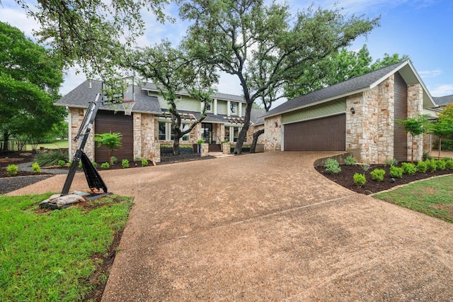 10305 Pickfair Dr, Austin, TX 78750 - view of front of home featuring stone siding, roof with shingles, and concrete driveway