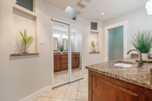 10305 Pickfair Dr, Austin, TX 78750 - full bath featuring two vanities, baseboards, tile patterned flooring, and recessed lighting