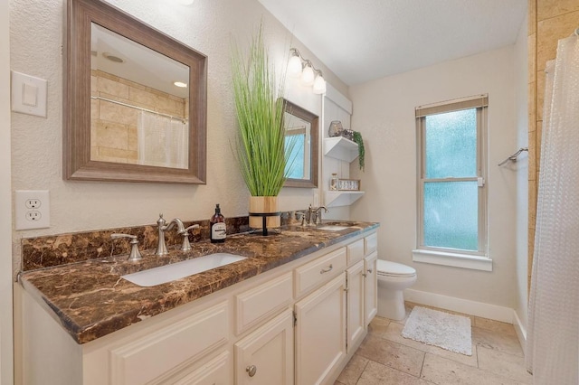 10305 Pickfair Dr, Austin, TX 78750 - full bathroom featuring double vanity, baseboards, toilet, curtained shower, and stone tile floors