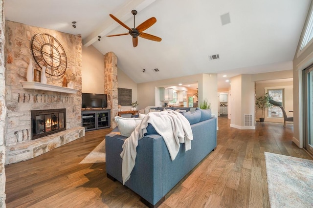 10305 Pickfair Dr, Austin, TX 78750 - living room with high vaulted ceiling, beam ceiling, a ceiling fan, a stone fireplace, and wood finished floors