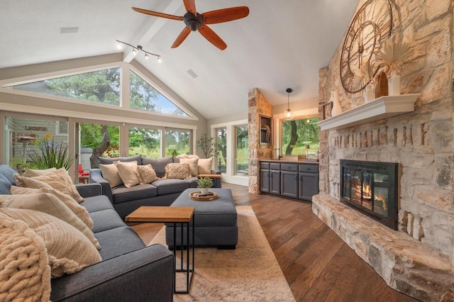 10305 Pickfair Dr, Austin, TX 78750 - living room featuring dark wood-type flooring, a ceiling fan, a fireplace, beamed ceiling, and high vaulted ceiling