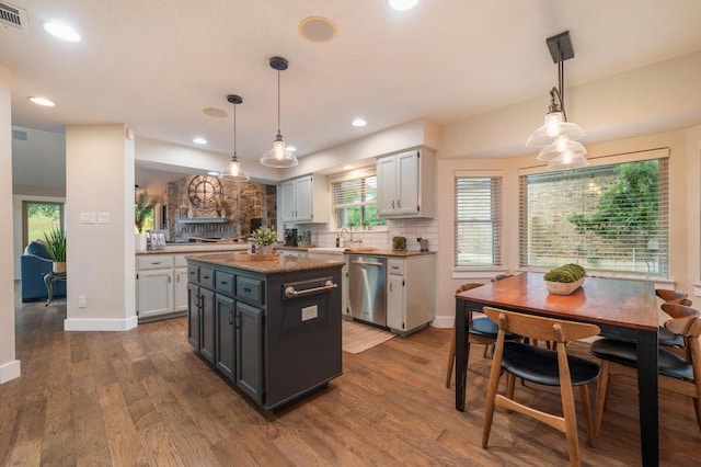 10305 Pickfair Dr, Austin, TX 78750 - kitchen featuring dishwasher, dark wood-style flooring, a sink, tasteful backsplash, and a center island