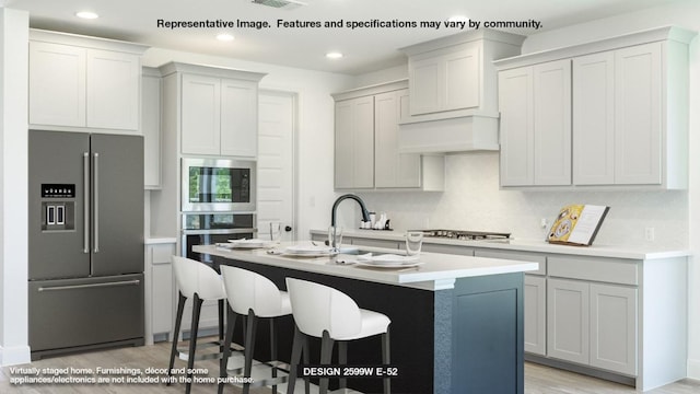 1121 Scenic Green Loop, Georgetown, TX 78628 - kitchen featuring appliances with stainless steel finishes, light wood-style floors, recessed lighting, an island with sink, and light countertops
