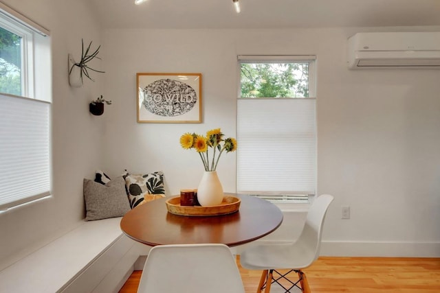 2000 E 8th St, Austin, TX 78702 - dining area featuring a wall mounted AC, wood finished floors, baseboards, and breakfast area