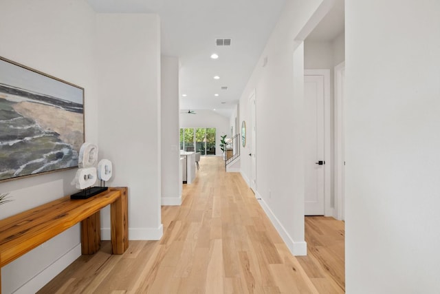 hall featuring light wood-style floors, baseboards, and recessed lighting