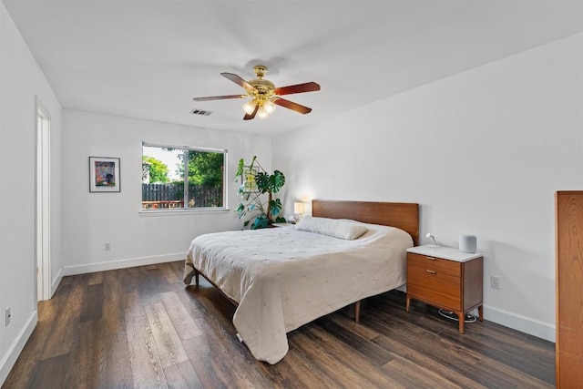 bedroom with dark wood-type flooring, baseboards, and a ceiling fan