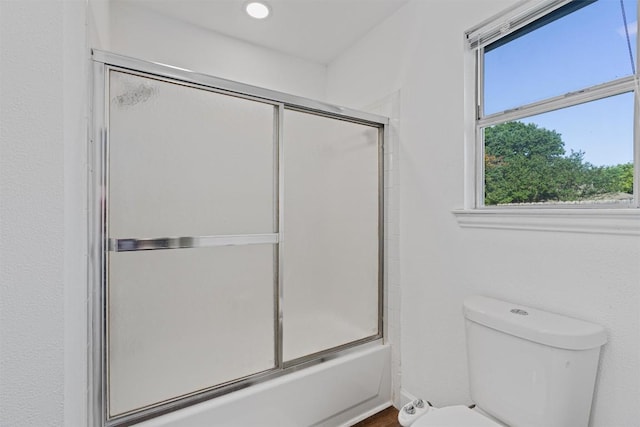 full bath with plenty of natural light, toilet, bath / shower combo with glass door, and recessed lighting
