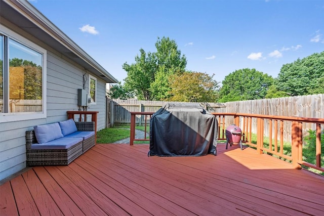 deck with a fenced backyard, a grill, and an outdoor hangout area