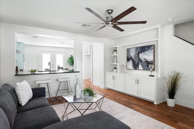89 Jan Ln, Georgetown, TX 78626 - living area with a ceiling fan, wood finished floors, built in shelves, and baseboards