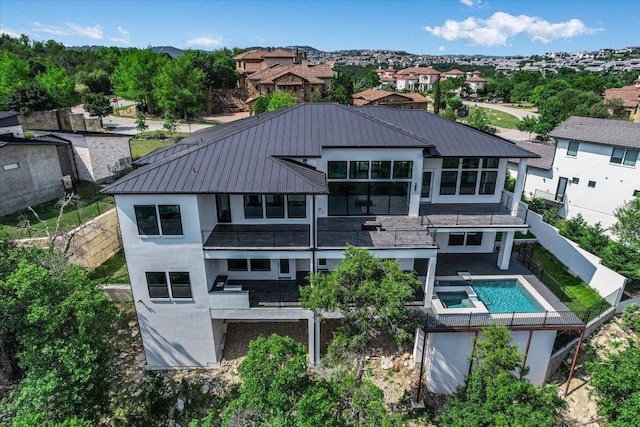235 Canyon Turn Trl, Austin, TX 78734 - rear view of property featuring a pool with connected hot tub, a residential view, stucco siding, and a standing seam roof