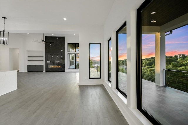 235 Canyon Turn Trl, Austin, TX 78734 - unfurnished living room featuring a ceiling fan, wood finished floors, built in shelves, a premium fireplace, and recessed lighting