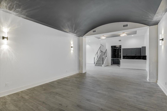 235 Canyon Turn Trl, Austin, TX 78734 - unfurnished room with baseboards, stairway, wood finished floors, and vaulted ceiling