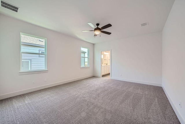 carpeted spare room with ceiling fan and baseboards