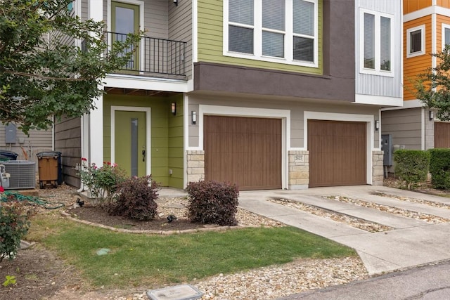 2621 Witsome Loop, Austin, TX 78741 - view of front facade with a balcony, an attached garage, concrete driveway, and central air condition unit