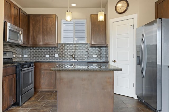 2621 Witsome Loop, Austin, TX 78741 - kitchen featuring appliances with stainless steel finishes, a kitchen island, dark stone counters, and tasteful backsplash