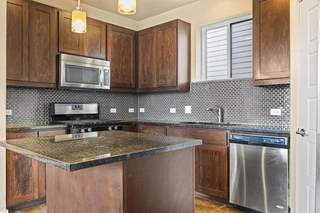 2621 Witsome Loop, Austin, TX 78741 - kitchen with stainless steel appliances, a sink, tasteful backsplash, dark stone countertops, and pendant lighting