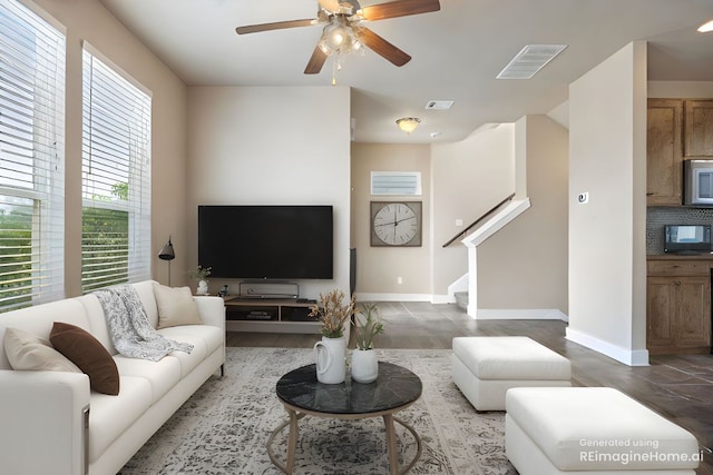 2621 Witsome Loop, Austin, TX 78741 - living room with a ceiling fan, stairs, baseboards, and wood finished floors