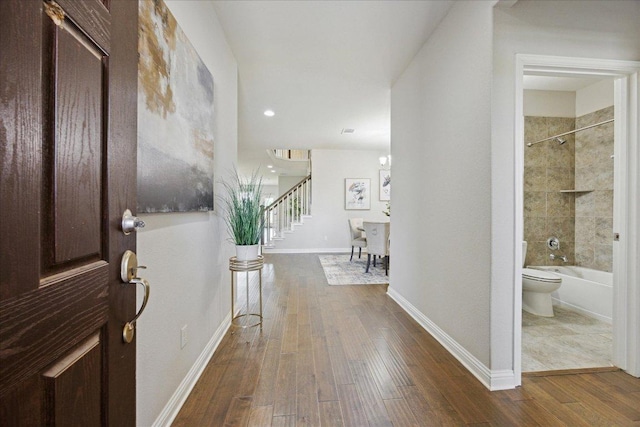 corridor with stairway, dark wood-style flooring, baseboards, and recessed lighting