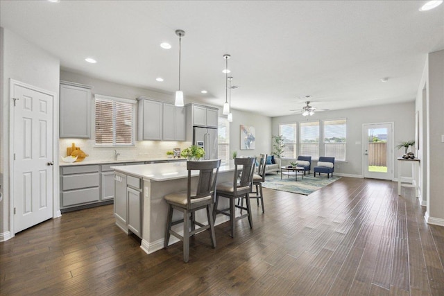 1716 Elaina Loop, Leander, TX 78641 - kitchen featuring gray cabinetry, high end fridge, light countertops, a breakfast bar area, and a kitchen island