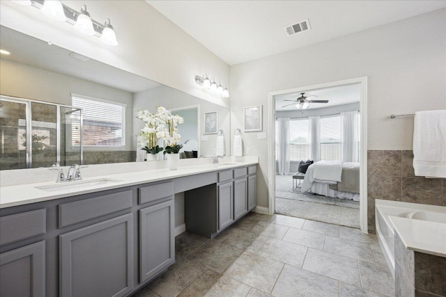 1716 Elaina Loop, Leander, TX 78641 - ensuite bathroom with double vanity, a bath, ceiling fan, a shower stall, and tile patterned flooring