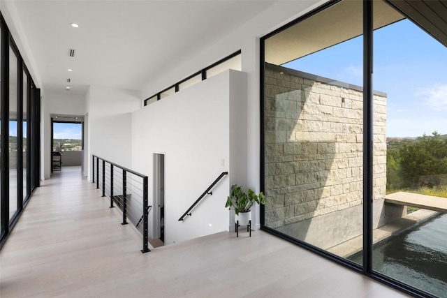 4202 Serene Hills Dr, Austin, TX 78738 - hallway with an upstairs landing, wood finished floors, recessed lighting, and a wall of windows
