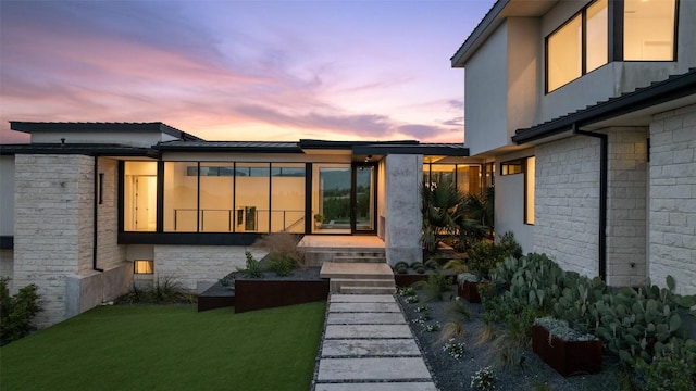 4202 Serene Hills Dr, Austin, TX 78738 - back of property at dusk featuring roof mounted solar panels and a yard