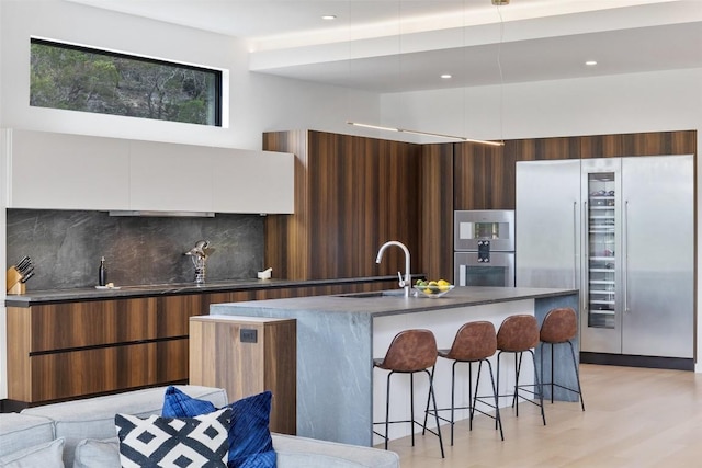 4202 Serene Hills Dr, Austin, TX 78738 - kitchen featuring appliances with stainless steel finishes, modern cabinets, a sink, backsplash, and recessed lighting