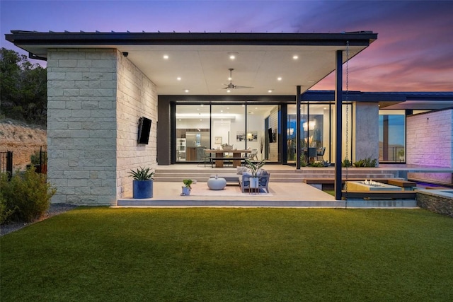 4202 Serene Hills Dr, Austin, TX 78738 - back of property at dusk with a patio area, a ceiling fan, and a lawn
