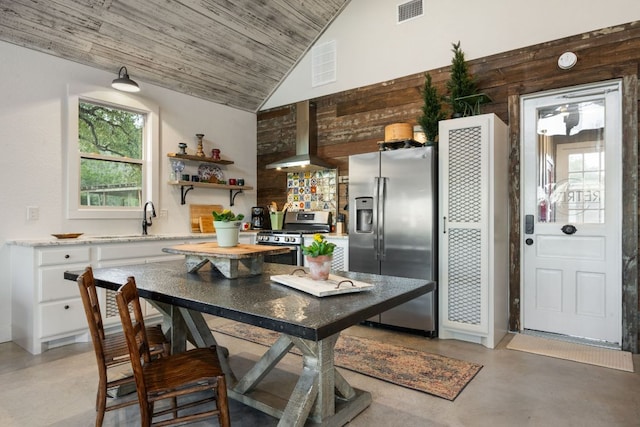 105 Valley View Trl, Comfort, TX 78013 - kitchen featuring stainless steel appliances, concrete flooring, a sink, wall chimney range hood, and white cabinetry