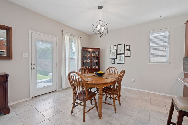 dining room featuring a chandelier, baseboards, and light tile patterned flooring