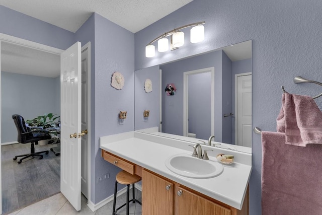 302 Debora Dr, Georgetown, TX 78628 - bathroom featuring toilet, vanity, a textured wall, baseboards, and a textured ceiling
