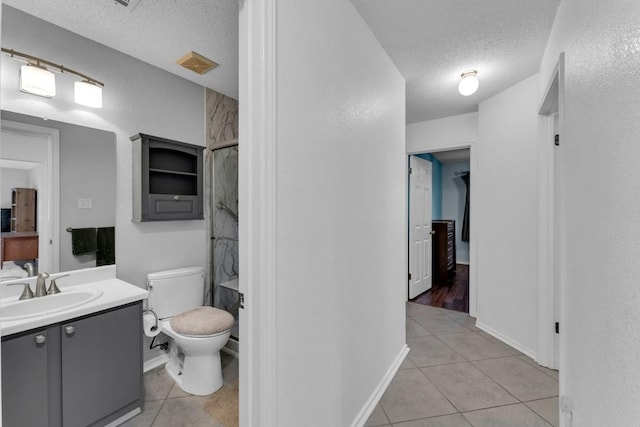 302 Debora Dr, Georgetown, TX 78628 - bathroom with a textured ceiling, tile patterned floors, vanity, toilet, and a shower